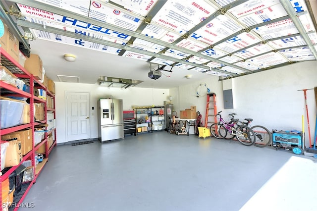 garage featuring a garage door opener, stainless steel refrigerator with ice dispenser, and electric panel