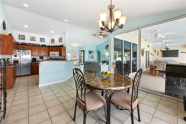 tiled dining area with lofted ceiling and an inviting chandelier