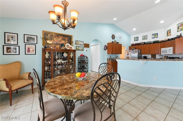 tiled dining room with vaulted ceiling and a notable chandelier