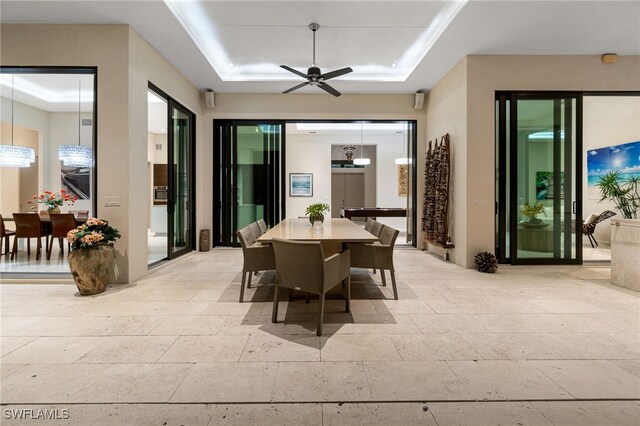 dining space with a raised ceiling and ceiling fan