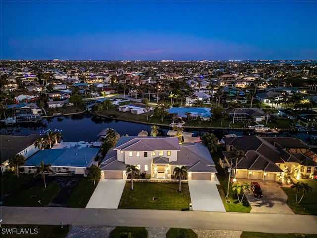 aerial view at dusk featuring a water view