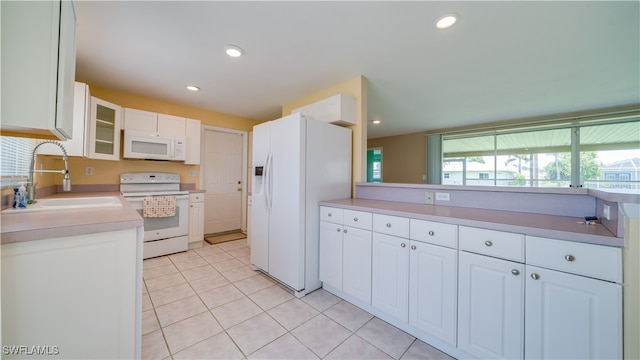 kitchen with sink, white cabinets, a healthy amount of sunlight, and white appliances