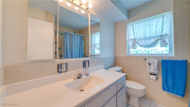 bathroom with vanity, tile walls, tile patterned flooring, toilet, and curtained shower