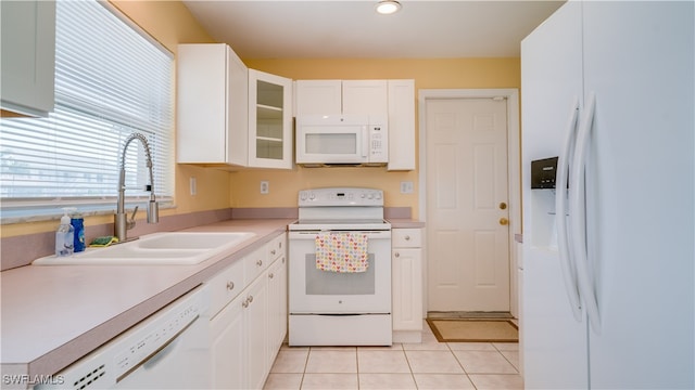 kitchen with white cabinets, white appliances, sink, and light tile patterned floors