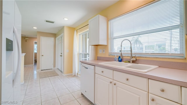 kitchen featuring light tile patterned flooring, white dishwasher, white cabinetry, and sink