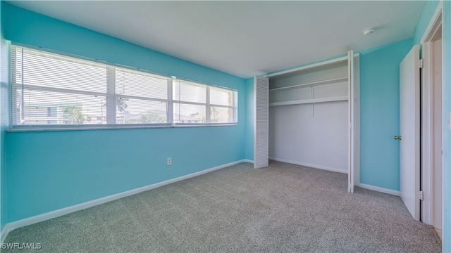 unfurnished bedroom with carpet, a closet, and multiple windows