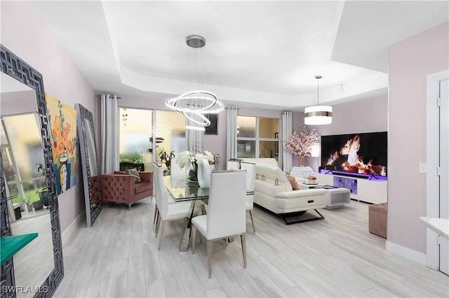 9801 Boraso Way Unit 103, Fort Myers, FL 33908 - dining space featuring a tray ceiling, light wood-style flooring, and a chandelier