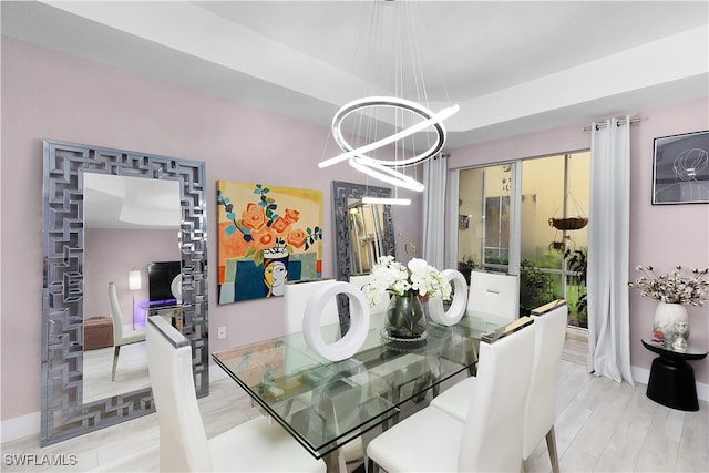 dining space featuring light hardwood / wood-style flooring and a notable chandelier