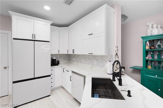 9801 Boraso Way Unit 103, Fort Myers, FL 33908 - kitchen with freestanding refrigerator, dishwashing machine, white cabinets, light stone countertops, and recessed lighting