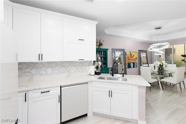 9801 Boraso Way Unit 103, Fort Myers, FL 33908 - kitchen with dishwasher, a peninsula, a chandelier, tasteful backsplash, and white cabinetry