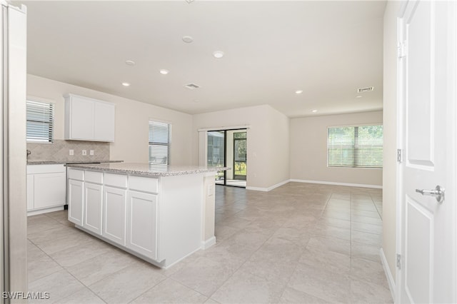 kitchen featuring a center island, a wealth of natural light, and white cabinets