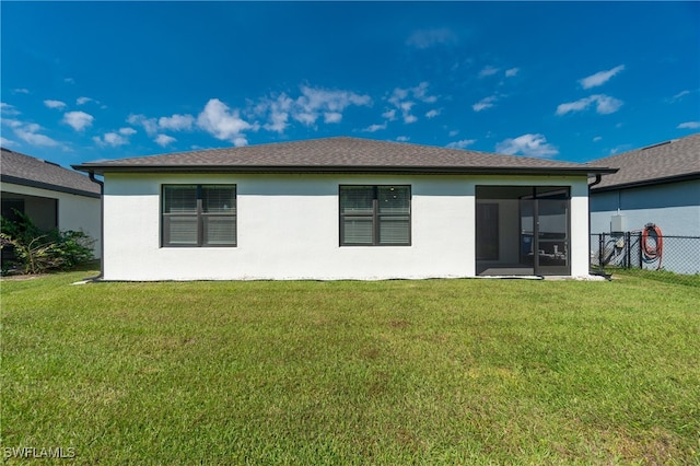 back of property featuring a yard and a sunroom