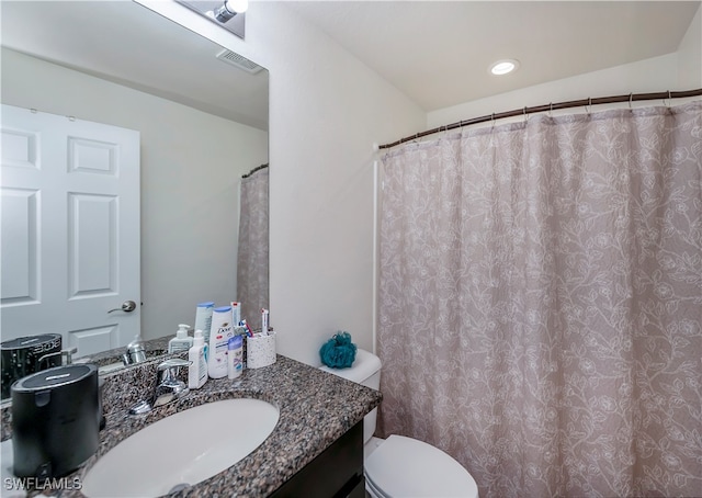 bathroom featuring vanity, walk in shower, and toilet