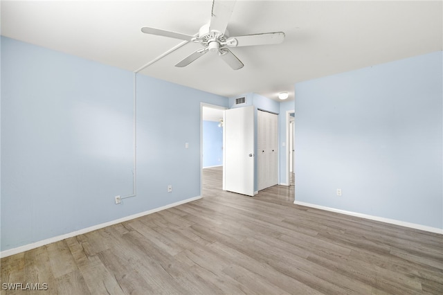 spare room with ceiling fan and light wood-type flooring