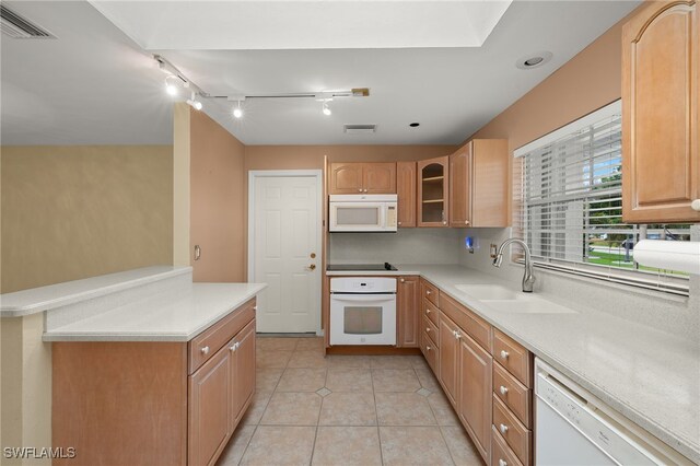 kitchen with light tile patterned flooring, sink, and white appliances