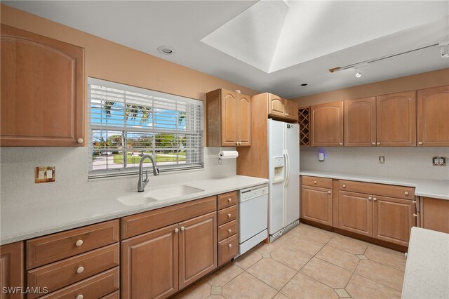 kitchen with sink, light tile patterned floors, white appliances, and decorative backsplash