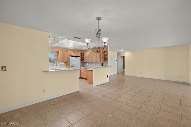 kitchen with white refrigerator with ice dispenser, kitchen peninsula, an inviting chandelier, and decorative light fixtures