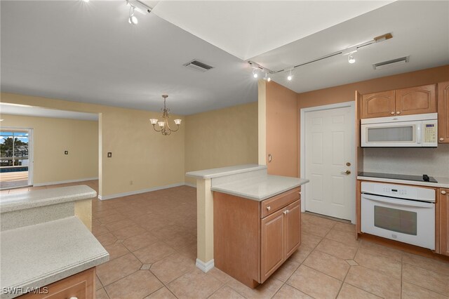 kitchen featuring a chandelier, pendant lighting, white appliances, and light tile patterned floors