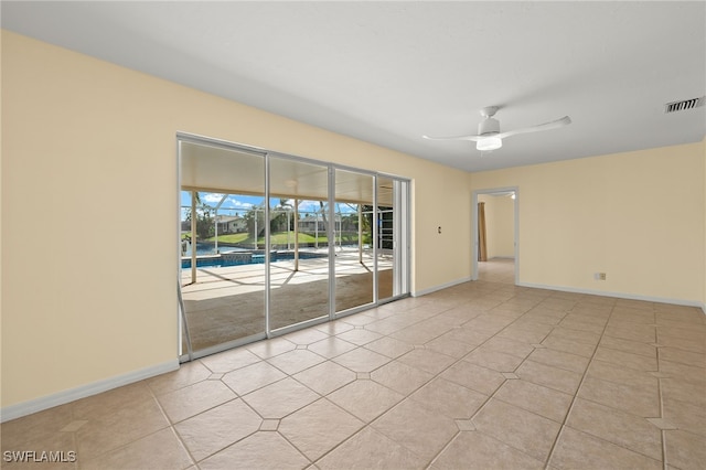 tiled spare room with ceiling fan