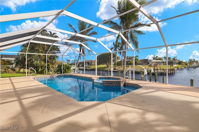 view of pool with an in ground hot tub, a water view, a patio area, and glass enclosure