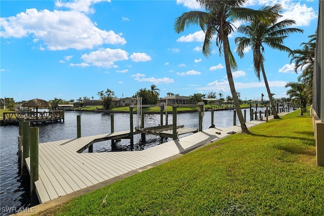 view of dock with a water view and a lawn