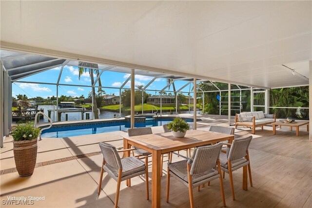 view of swimming pool with a lanai, a water view, an outdoor hangout area, and a patio area