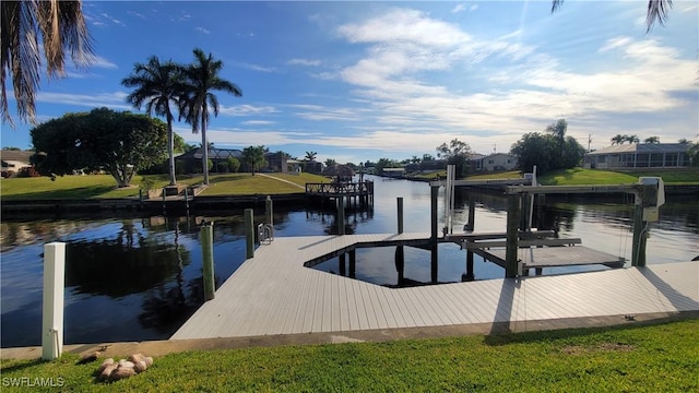 view of dock with a water view and a lawn