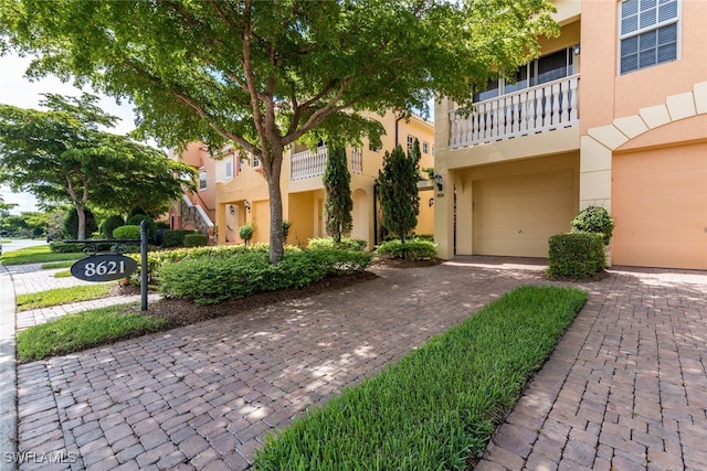 view of front of home featuring a garage and a balcony