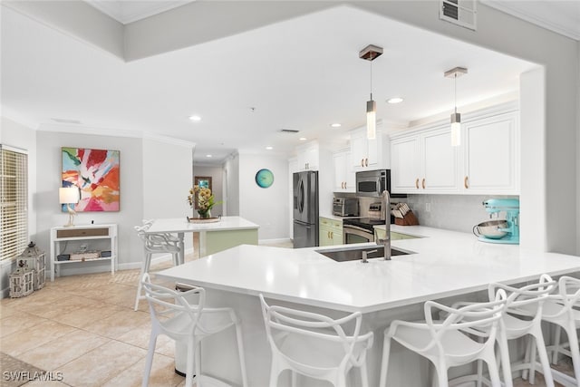 kitchen with a breakfast bar, kitchen peninsula, appliances with stainless steel finishes, tasteful backsplash, and hanging light fixtures