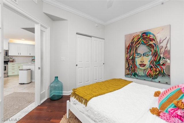 tiled bedroom with a closet, ceiling fan, and ornamental molding