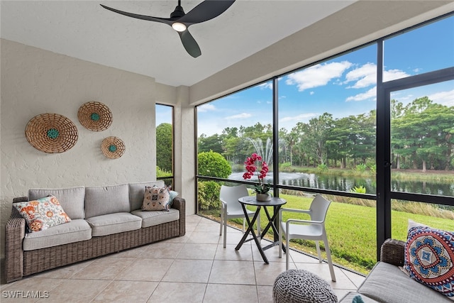 sunroom / solarium featuring ceiling fan and a water view