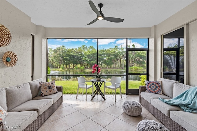 sunroom with a wealth of natural light, a water view, and ceiling fan