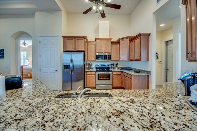 kitchen featuring light stone counters, sink, and stainless steel appliances