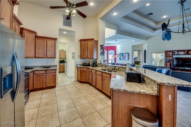 kitchen featuring appliances with stainless steel finishes, ceiling fan, crown molding, sink, and a breakfast bar area