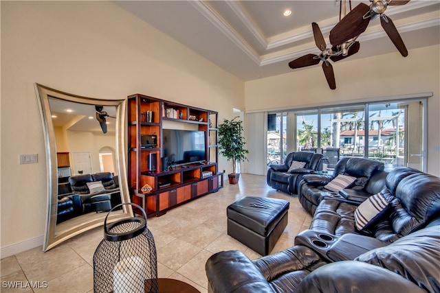 living room with ceiling fan, a towering ceiling, light tile patterned floors, and ornamental molding