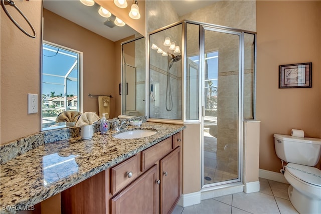 bathroom featuring tile patterned floors, vanity, toilet, and a shower with door