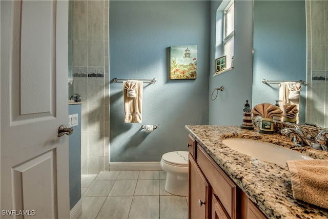 bathroom featuring tile patterned flooring, vanity, and toilet