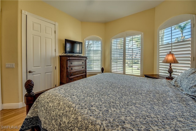 bedroom with wood-type flooring and multiple windows