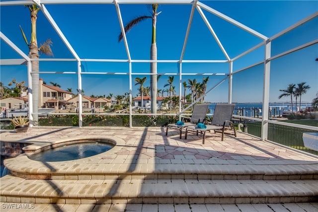 view of patio featuring an in ground hot tub and a lanai