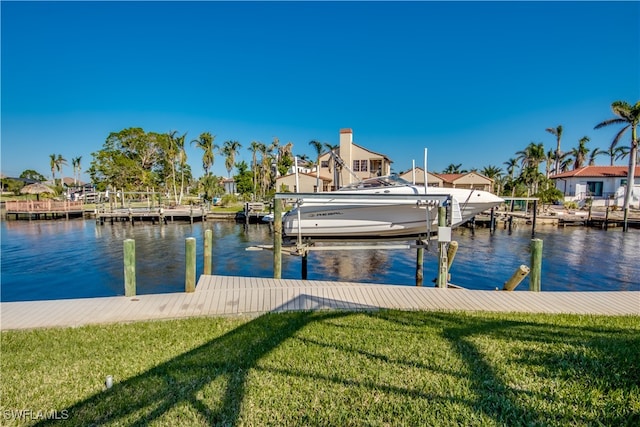 dock area with a lawn and a water view