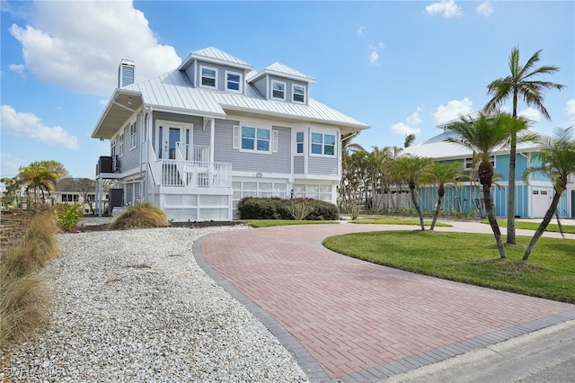 view of front of home with a front yard, covered porch, and a garage