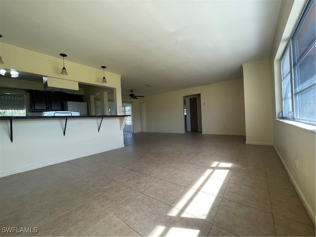 unfurnished living room with ceiling fan and light tile patterned floors