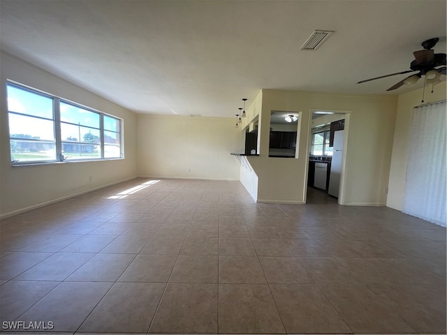 unfurnished living room featuring tile patterned floors and ceiling fan