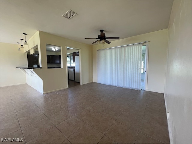 unfurnished living room featuring dark tile patterned floors and ceiling fan