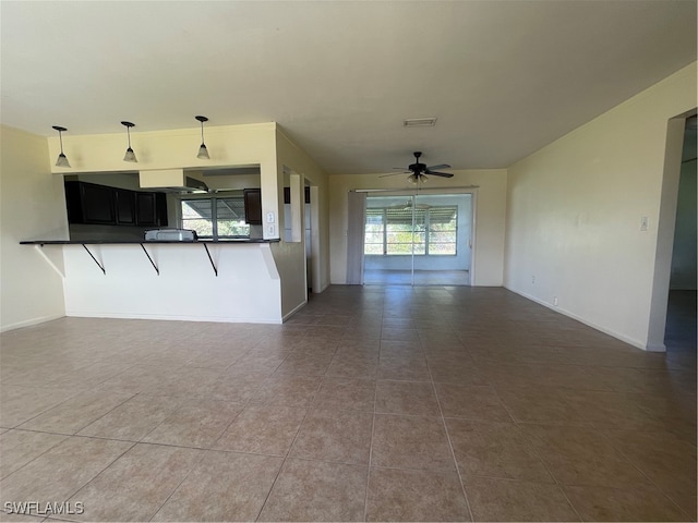 unfurnished living room with ceiling fan and tile patterned flooring