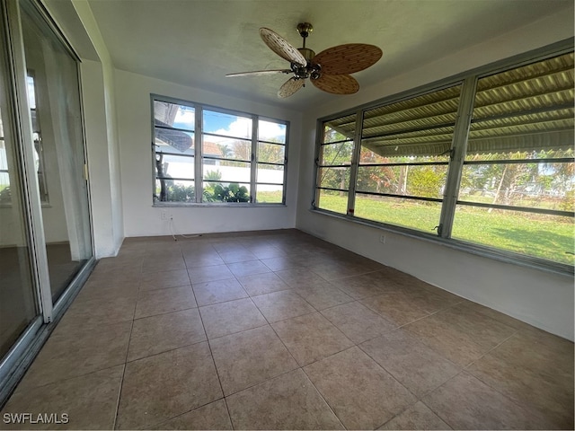 unfurnished sunroom featuring ceiling fan