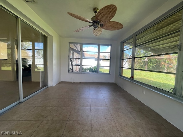 unfurnished sunroom with ceiling fan