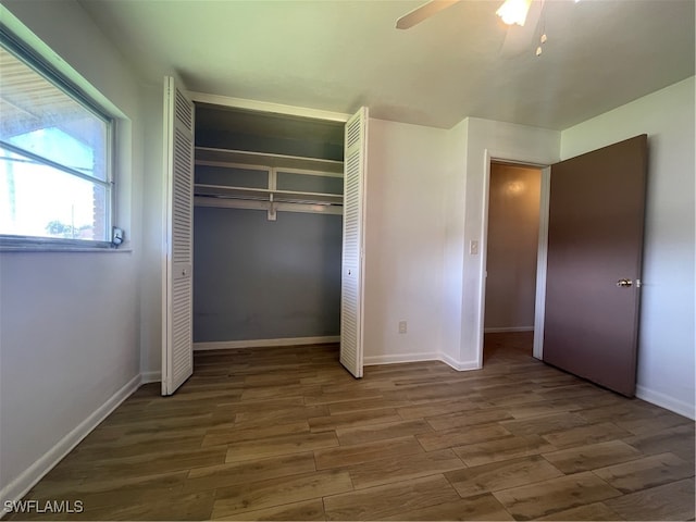 unfurnished bedroom featuring a closet, ceiling fan, and dark hardwood / wood-style flooring