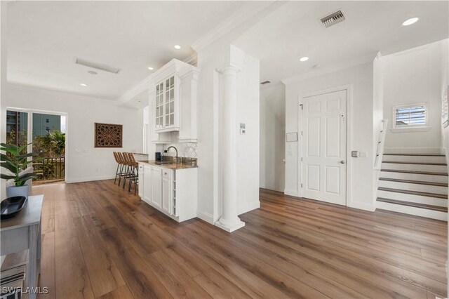 270 Delmar Ave, Fort Myers Beach, FL 33931 - kitchen with ornamental molding, a sink, white cabinets, dark wood-style floors, and glass insert cabinets