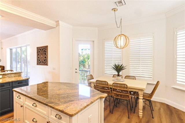 270 Delmar Ave, Fort Myers Beach, FL 33931 - kitchen featuring light wood-style floors, light stone counters, crown molding, hanging light fixtures, and a center island
